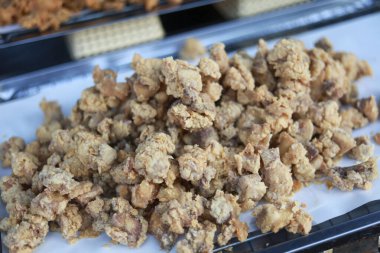 Metal tepside çıtır çıtır kızarmış tavuk derisi. Lezzetli, leziz ve kıtır kıtır kıtır kızarmış atıştırmalıklar.