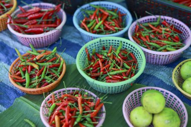 Yerel pazardaki renkli sepette taze kırmızı ve yeşil biber ve limon karışımı, baharatlı ve organik ürünler otantik lezzet ve renkle dolu.