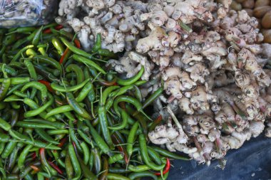 Marketten taze yeşil biber ve çiğ zencefil kökü al. Renkli yemek malzemeleri, sağlıklı yiyecekler için baharat ve lezzet dolu.