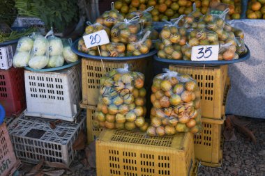 Açık hava pazarında satılık taze portakal meyveleri sergileniyor. Bu sağlıklı besinler, turunçgillerin ürettiği türler, yerel ve otantik bir ticaret duygusunu çağrıştırıyor.