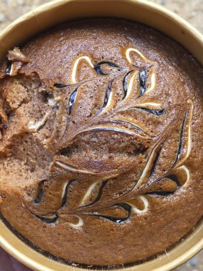 Dekoratif girdap desenli nefis ev yapımı kahveli kek. Yuvarlak tavada pişmiş bu nefis kahverengi şey zengin ve rahatlatıcı görünüyor.