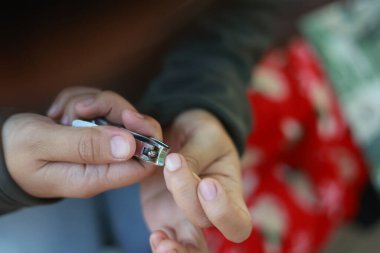 Odaklanmış kişi tırnak makasıyla dikkatlice tırnak kesiyor. Bu el bakımı ve hijyen rutini, kişisel bakım ve sağlığını temiz ve kısa tırnak bakımıyla gösteriyor.