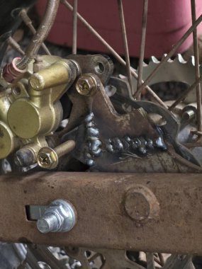 Fren ayarlayıcısı için çelik parantez üzerindeki özel kaynak. Bu motosiklet metali, imalat, onarım ve modifikasyonun cesur detaylarını gösteriyor.