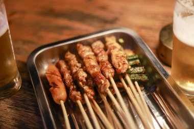 Izakaya soslu soğuk birayla ızgara et şişi. Metal tepside servis edilen lezzetli yemekler, lezzetli yemekler ve sosyalleşme için mükemmel.