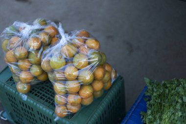 Yerel gıda pazarında satılık taze turuncu turunçgil meyvesi. Naylon poşette paketlenmiş sağlıklı organik ürünler, satın alınmaya hazır, basit, doğal duyguları çağrıştırıyor.