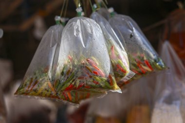 Asya 'daki bir gıda pazarında şeffaf plastik poşette asılı baharatlı taze biber ve sebze karışımı. Canlı, otantik Tayland malzemelerini pişirmeye ve satışa hazır hale getirin.