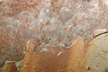 Eski, yıpranmış metal bir yüzeyde paslanma ve aşınma olduğunu gösteren soyut bir arkaplan. Kahverengi doku endüstriyel bozulma ve yaşlanma hissi yaratır.