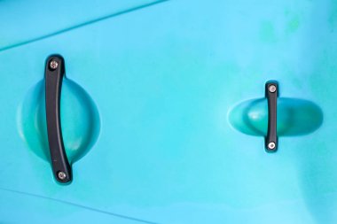 İki siyah saplı turkuaz plastik yüzeyin temiz, modern, soyut arka planı. Bu basit ve minimalist detay çekiminin parlak rengiyle eğlenceli bir hissi var.