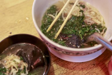 Sıcak ve lezzetli Japon erişteli erişte çorbasını yemek çubuklarıyla yakından izleyin. Bu otantik, rahatlatıcı yemek çorba, sebze ve yosun içerir.