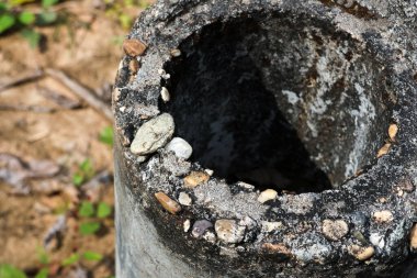 Çürümeyi gösteren eski, kırık beton bir direğin makro ayrıntıları. Yıpranmış doku ve hasarlı delik yıpranmış yapıyı ve yıpranmış yüzeyi gösteriyor.