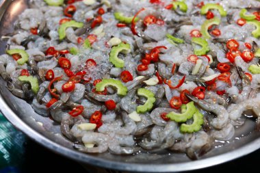 Baharatlı çiğ karides salatası, Tayland yemeği deniz ürünleri aperatifi. Acı biberli karides, sarımsak ve acı kavun tabakta. Lezzet ve iştah açıcı yemekler yaratıyor.