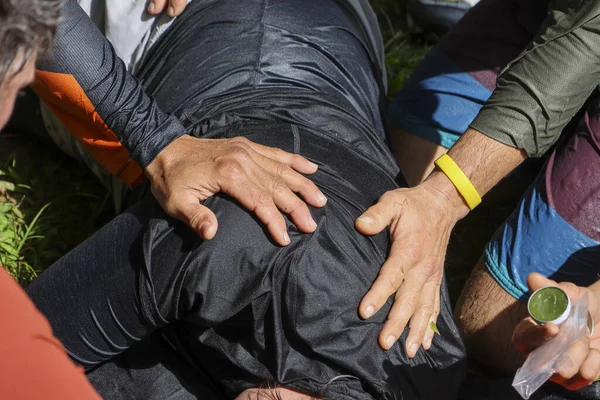 Acil kurtarma sahnesini kapatın. Bakım ve endişeyle yaralanan kişiye yardım eden ekip çalışması, açık hava krizi sırasında yerde yatan kurbana acil ilk yardım desteği sağlıyor.