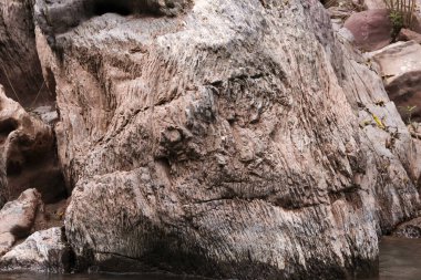 Büyük doğal taşı, pürüzsüz dokulu yüzeyi ile kapatın. Huzurlu nehir akıntısında sabit durun. Doğanın zamansız gücünü ve aşınmış mineral yapısının jeolojik detaylarını aktarın.