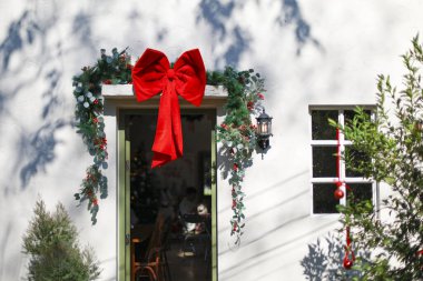 Noel için süslenmiş, yeşil kapının üzerinde büyük kırmızı bir fiyonk ve neşeli kış mevsimi kutlama ruhunu gösteren tatil çelengi ile süslenmiş Beyaz Saray 'ın dışı.