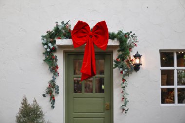 Beyaz Saray 'ın ön kapısının üzerinde büyük kırmızı pruva ve yeşil çelenk bulunan mutlu noel süslemeleri kış kutlaması sezonu için bayram atmosferi yaratıyor.