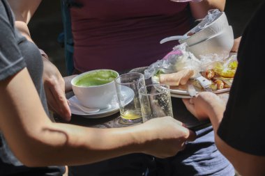 Garson bulaşıkları yıkar, tepsiyi dağınık yemek artıklarıyla, boş bardaklarla taşır ve öğle yemeğinden sonra yararlı ve çalışkan servis kavramını gösteren yoğun bir restoranda peçete kullanır.