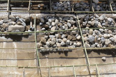 Sağlam beton yüzeyde erozyon koruması için güçlendirilmiş ağır taş bariyer ızgaralı inşaat projesi endüstriyel dayanıklılık ve dayanıklılık gösteriyor