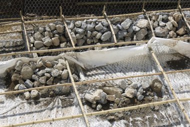 Taştan iskeleti ve sağlam endüstriyel mühendisliği ihtiyatlı ve organize edilmiş sağlam endüstriyel mühendislik içeren güçlendirilmiş yol kenarı duvar koruma yapısının yapımı.