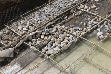 Altyapı geliştirme ve güçlendirilmiş nehir kenarı inşaatı, taş ve bambu şebeke çerçevesi kullanılarak yapılmaktadır.