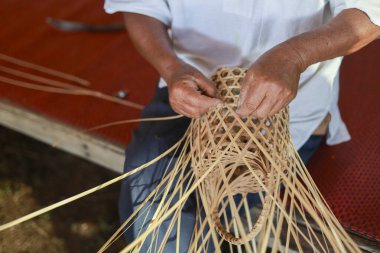 Yetenekli el sanatları ustalarının elleri, karmaşık bambu sepetleri ve kültürel mirası gösteren geleneksel el yapımı el sanatları.