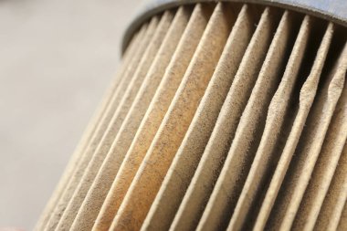 Kirli hava filtresi deseninin detaylarını kapat. Kumla kaplanmış kahverengi katmanlı kağıtların emme verimliliğini artırmak için bakım ve temizlik gerektirdiğini göster.