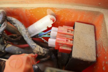 Eski turuncu bağlantı kutusunun içindeki konnektörlü kirli elektrik teli sistemi, karmaşık karmaşık devreyi ve endüstriyel makine güç kaynağının bakımı için teknik bağlantıyı gösteriyor