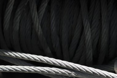 Güçlü endüstriyel metal deseni ve ağır inşaat malzemesi detaylarını gösteren sıkıca sarmalanmış kalın çelik tel halat kablosunun monokromatik desen görünümünü kapat