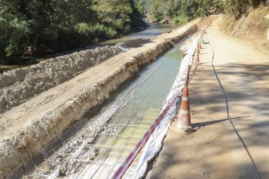 Kırsal alanda endüstriyel gelişim ve mühendisliğin ilerlediğini gösteren nehir akıntısı yakınındaki inşaat inşaat inşaat inşaat alanı ve inşaat demiri şebekesi.