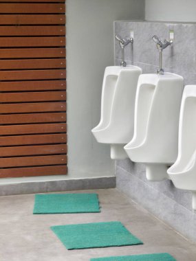 Modern halka açık tuvaletlerde temiz beyaz seramik pisuar tuvaletleri sakin sakin iç tasarımı hijyen ve hijyen kavramını gösteriyor.