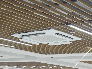 Modern beyaz tavan kaset klima soğutma ofisi ahşap slat tasarımı ve doğrusal ışıklandırma kapalı alanda üretken çalışma ortamı için rahat profesyonel atmosfer oluşturur