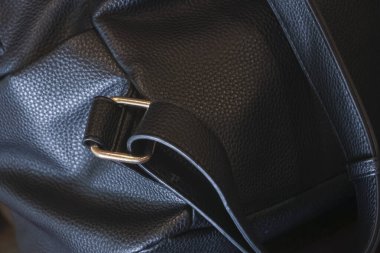 Detaylı siyah deri çanta desenini metal tokalı kayışla kapatın. Zarif, sofistike bir stil işçiliği, lüks dikiş, sağlam moda aksesuar valizleri.