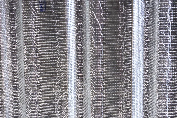 Gümüş metalik yalıtım folyo malzemesinin dokusu dikey çıkıntılar ile kapanıyor. Sıcaklığı kontrol altına almak için sağlam endüstriyel yüzeyi gösteren çatı arkası konsepti.