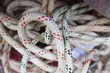 Güçlü naylon tırmanma ipinin soyut karışıklığını kapat. Karmaşık bir yığın halinde birbirine dolanmış. Sağlam dokuyu ve güvenli bağlantıyı göster.