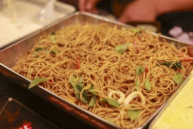 Fesleğenli kızarmış şehriye ve metal tablada kalamar halkaları parti büfesi ya da öğle yemeği servisi için hazır. Restoran misafirleri için lezzetli ve lezzetli görünüyor.