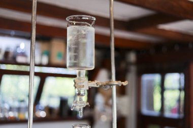 Yavaş damlayan soğuk kahve makinası, cam kaptan dökülen su damlası ile sıcak kafe iç kısımlarında metal klempler ile tutulan sabır ve hassasiyeti aktaran.