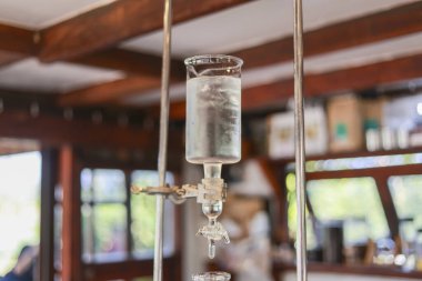 Soğuk demleme kahve damlaları, kafeteryada damla damla içecekler üretiyor. Saf içeceği filtrelemek için şeffaf cam ekipmanlarla sabır ve sükunet gösteriyorlar.