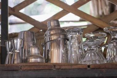 Ahşap rafta sallanan ve şıngırdayan bar ekipmanları hazır kokteyl için kırsal tezgahta neşeli bir atmosfer ve hazırlık ile karıştırılmaya hazır