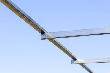 İnşaat halindeki çelik çatı kirişinin yapısı, mavi gökyüzü, konut veya endüstriyel yapı iskeleti için modern mühendislik tasarımında güç ve istikrar gösteriyor.