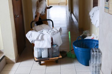Otel hizmetçisi koridorda içi temiz çarşaf dolu servis arabasını itiyor. Bu kendini işine adamış personel günlük rutinini gerçekleştiriyor, konukseverlik ve oda servisi sağlıyor.