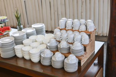 Lokantada açık büfe servisi için bir sürü fincan, kase ve tabakla birlikte temiz beyaz seramik sofra takımı. Düzenli ekran, düzenlilik ve hazırlık duygusunu ifade eder