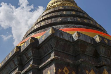 Tayland 'daki tapınakta görkemli antik bir stupa. Budist binasının düşük açılı görüntüsünde mavi gökyüzü altında güzel Asyalı mimari, kültür ve din sergileniyor.