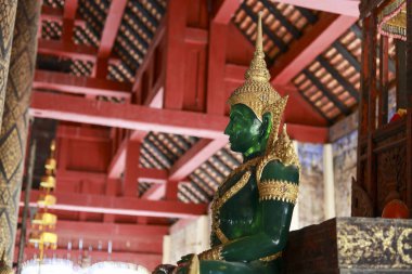 Yüce yeşil Buda heykeli kutsal Asya tapınağında huzur içinde duruyor. ruhani sanat eserleri ve antik mimari sakin ve tarihi bir atmosfer yaratır.