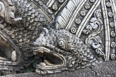 Bali tapınağındaki efsanevi ejderha yılan kafasının detaylı taş oymasını kapat. Bu antik, süslü ve dini heykel vahşi bir ifade sergiliyor.