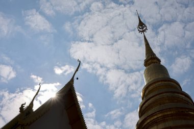 Serene gold stupa ve tapınak çatısının silueti mavi gökyüzüne karşı. Tayland 'daki bu ruhani Budist mimari huzur ve huşu uyandırıyor.