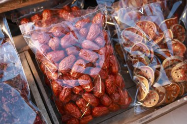 Elektrikli süpürge paketinde sağlıklı kurutulmuş kırmızı randevu meyvesi. Market rafında satılık tatlı meyve suyu ve geleneksel Asya atıştırmalığı manzarası.