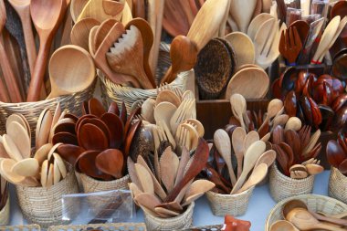 El yapımı ahşap kaşık ve çatal bıçak koleksiyonu sergileniyor. Satılık çeşitli kahverengi mutfak aletleri, geleneksel zanaatkarlığı gösteriyor