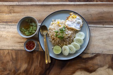 Asya usulü iştah açıcı yemek, kızarmış yumurta, salatalık ve tabakta çorba. Sıcak hissetmek için ahşap masada sunulan lezzetli ve rahatlatıcı öğle yemeği.