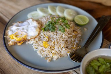 Lezzetli ve lezzetli bir tabak Tayland pilavı, ayrıca Khao Pad olarak da bilinir, kızarmış yumurta, salatalık dilimleri ve limon dilimleri ile servis edilir. tam Asya yemeği