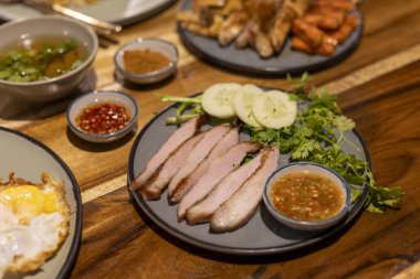 Lezzetli ızgara domuz eti, dilimlenmiş etle geleneksel Tayland yemeği, taze salatalık, kişniş ve baharatlı sos ile servis edilmiş. Restoranda nefis Asya mutfağı yemeği