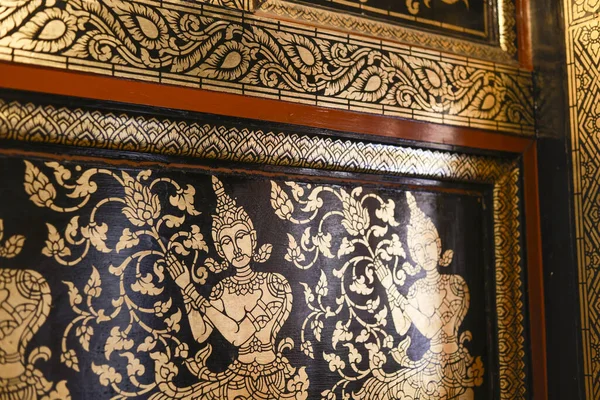 Geleneksel desenlerin karmaşık Tayland sanat altın yaldızlı boyası. Tapınaktan dekoratif tasarım çiçek motifleri arasında dingin bir tanrı olduğunu gösteriyor, güzel bir kültür başyapıtı.